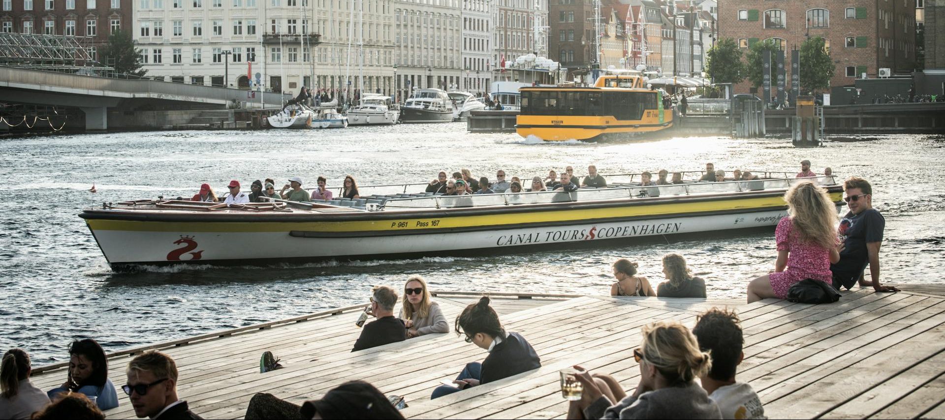 Is Aarhus Denmark a Good Place to Live, Copenhagen, Denmark People sitting on the dock watching a boat